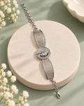 Honeycomb Gleam Bracelet with silver-tone honeycomb panels and a sparkling circular centrepiece on a sage background