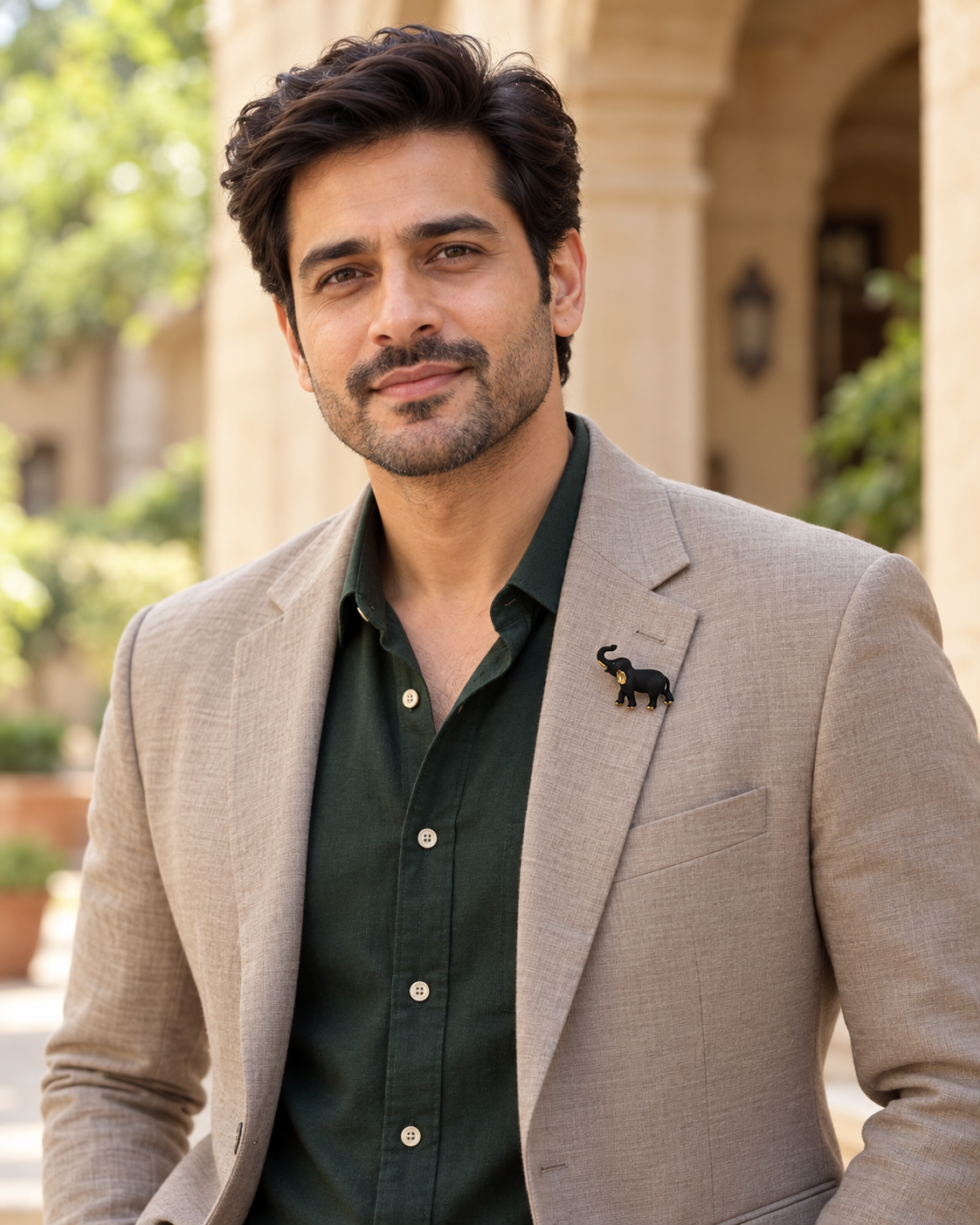 Midnight Tusker Brooch worn as a small pin on a male model's light taupe blazer in an outdoor courtyard