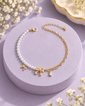 Pearl Bow Bracelet with pearl-like beads and gold-tone bow details on lavender display