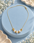 Pearl Petal Necklace on a powder-blue display