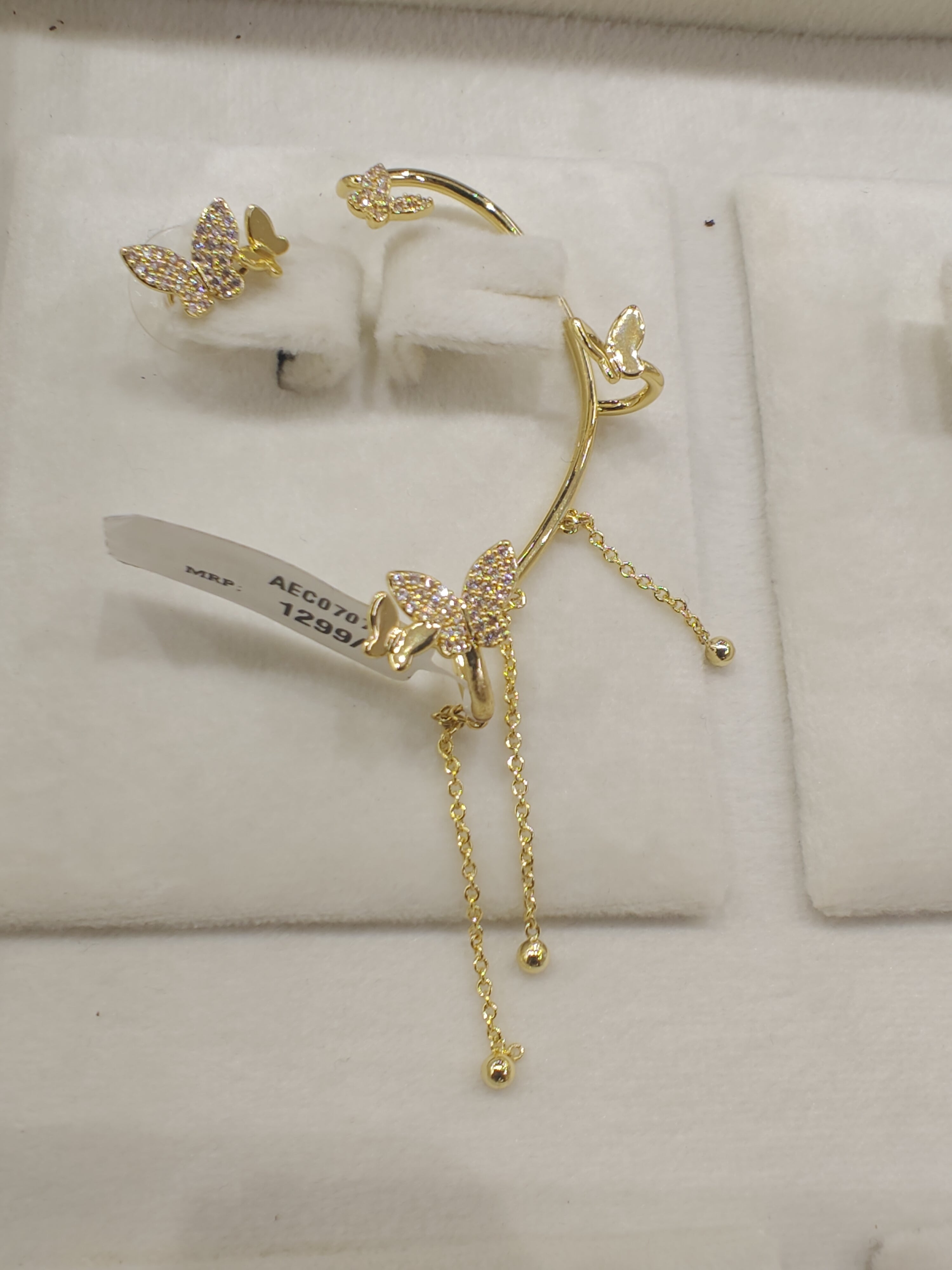 Gold butterfly earrings on a white background