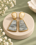Slate Dusk Earrings with cream studs, grey marbled drops and gold-tone borders on an ivory pedestal