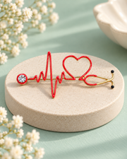 The Care Code Brooch with red heartbeat, open heart and stethoscope design on a mint and ivory background