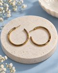 The Effortless Arc Hoops with a smooth gold-tone open hoop design